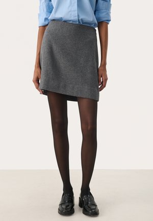 Grey wool mini skirt with an asymmetrical hem. Paired with black tights and chunky black loafers, creating a textured layered look.