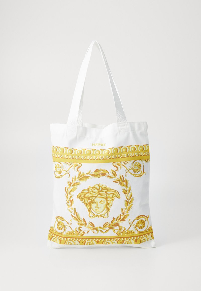 Saco tote branco com padrão baroque dourado e emblema de Medusa, com alças planas e um design simples e sem adornos.