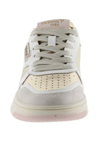 White and beige sports sneaker with a textured leather upper, perforated toe box, and flat laces. Features pink accents on sole.