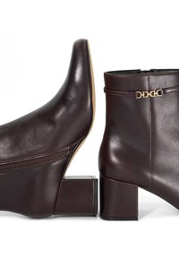 Brown leather ankle boots with a block heel. Features a zipper on one side and a gold-tone accent strap on the other. Smooth texture.