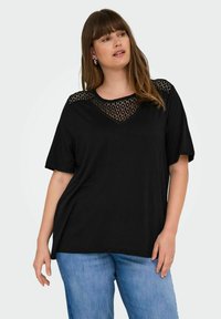 Svart kortärmad T-shirt med en texturerad spetsdetalj. Den avslappnade passformen och V-ringningen ger komfort och andningsförmåga.