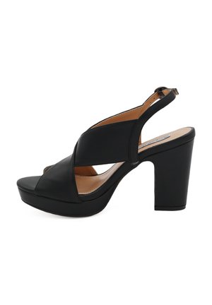 Sandalette nera con tacco alto e suola piattaforma, realizzata in pelle liscia, presenta cinturini incrociati e una chiusura con fibbia sul tallone.