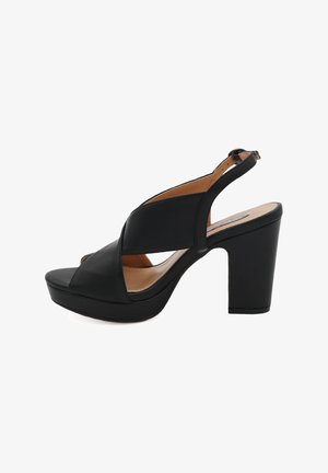 Sandalette nera con tacco alto e suola piattaforma, realizzata in pelle liscia, presenta cinturini incrociati e una chiusura con fibbia sul tallone.