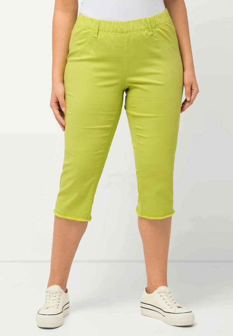 Groene cropped broek met een elastische tailleband, twee zijzakken en een contrasterende stiksels aan de onderkant. G คาភេরা რრეცრუქტიდმო ქ რპომდბა. 