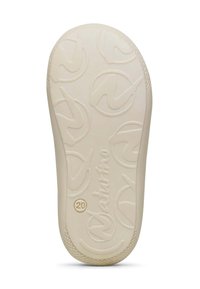 Suela de zapato en goma blanco roto, con patrones de logo en relieve y textura antideslizante en los bordes, con un diseño circular.