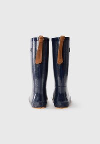 Bottes de pluie paillettes bleu marine avec une finition lisse, des poignées en cuir brun, et des semelles en caoutchouc texturé, conçues pour la durabilité et la résistance à l'eau.