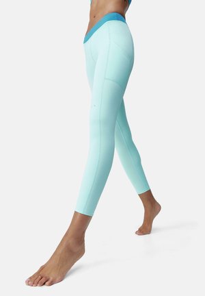 Leggings actifs bleu clair avec une taille contrastante bleu foncé. Texture lisse, design ajusté et détails de couture sur les jambes.
