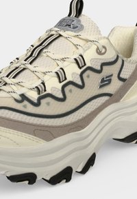Μπεζ και γκρι sneaker με κορδόνια, παχιά σόλα, υφασμάτινο επάνω μέρος με υφή, κυματιστό πλευρικό σχέδιο και το επώνυμο λογότυπο "S" στο πλάι.