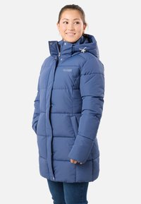 Blå pufferjacka med huva, framdragkedja och tryckknappar. Quiltad design med rymlig passform och sidofickor. Mjuk, isolerad textur.