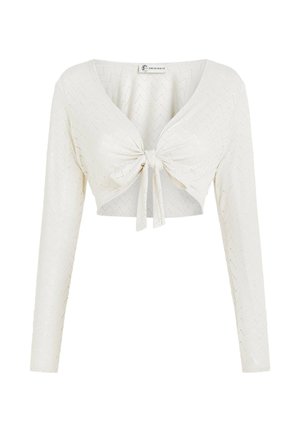 Λευκό κοντό τοπ με μακριά μανίκια, V-λαιμόκοψη και δέσιμο μπροστά. Διαθέτει υφασμάτινο ανάγλυφο ζιγκ ζαγκ μοτίβο σε όλο το ύφασμα.