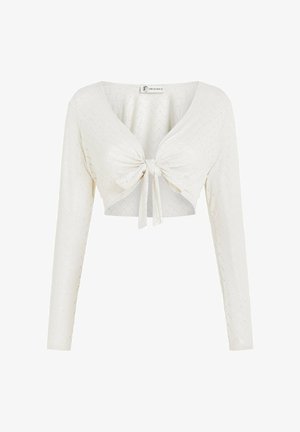 Λευκό κοντό τοπ με μακριά μανίκια, V-λαιμόκοψη και δέσιμο μπροστά. Διαθέτει υφασμάτινο ανάγλυφο ζιγκ ζαγκ μοτίβο σε όλο το ύφασμα.