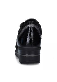 Sneaker in pelle nera con finitura lucida, caratterizzato da una suola nera spessa e una cerniera laterale. Il design include dettagli in tessuto testurizzato.