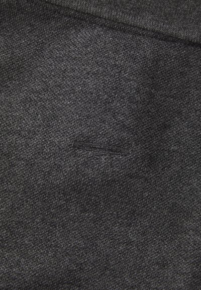 Tissu gris foncé montrant un tissage texturé avec une surface légèrement inégale et un petit détail de couture subtil.