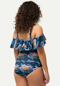 Maillot de bain une pièce avec un motif abstrait bleu, conception à volants sans épaules et bretelles réglables. Tissu lisse et extensible.