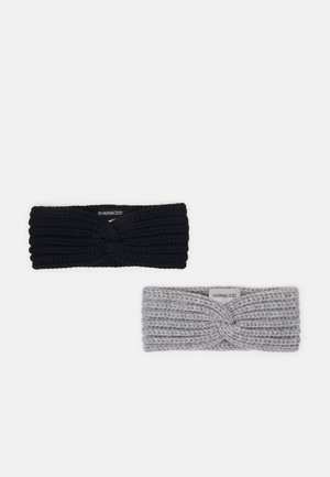 Deux bandeaux tricotés avec un détail torsadé, un noir et un gris, chacun avec une petite étiquette en tissu portant la mention even&odd.