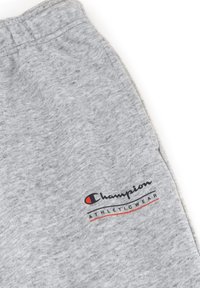 Grijze katoenen sweatpants met een zachte textuur, een elastische tailleband en een geprinte logo in zwart, rood en wit op de dij.