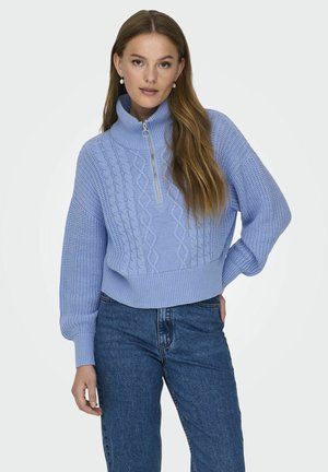 Lys blå genser med høy krage, glidelås og kabelstrikket mønster. Har et kort design og ribbestrikkede mansjetter og hem.