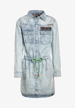 Robe en denim bleu clair avec manches longues, boutonnée à l'avant, poches poitrine ornées de patchs brodés multicolores, et taille à cordon vert.
