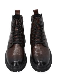 Brązowe skórzane kobiece botki za kostkę z zaokrąglonym noskiem, sznurowanym przodem i zamkiem błyskawicznym z boku; teksturowane wykończenie z grubą gumową podeszwą.
