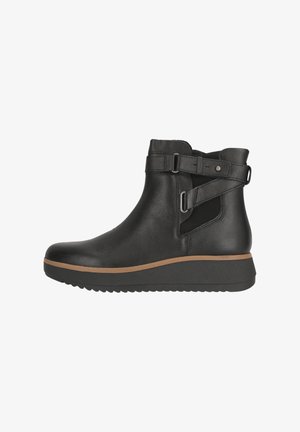 Schwarze Leder-Stiefeletten mit verstellbaren Riemen und seitlichen elastischen Einsätzen, ausgestattet mit einem strukturierten Obermaterial und einer dicken Gummisohle mit einem hellbraunen Akzent.