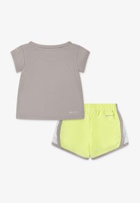 Grey DRI-FIT t-shirt with short sleeves paired with neon yellow shorts, featuring mesh side panels and elastic waistband.