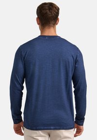 Marineblaues Langarmshirt aus strukturiertem Stoff mit Rundhalsausschnitt und taillierter Passform. Keine sichtbaren Logos oder Verzierungen.