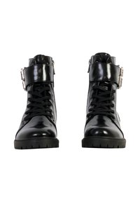 Botines de charol negros con cordones en la parte delantera y un detalle de hebilla lateral. Presentan una suela de goma texturizada y un acabado suave.