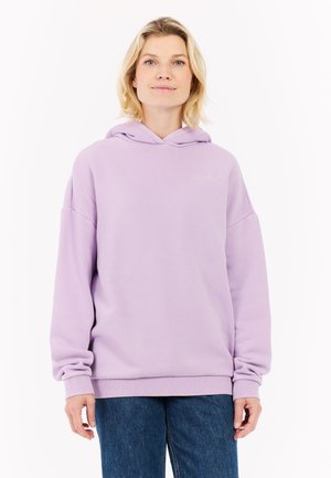 Haut à capuche lavande en tissu doux avec une coupe ample, featuring une poche avant et des poignets côtelés. Détail de logo subtil sur la poitrine.