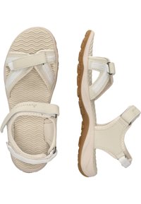 Beige sandaalit, joissa on teksturoitu kumipohja ja valkoiset kangasremmit. Varustettu säädettävällä soljella ja muotoillulla pohjalla mukavuutta varten.