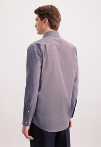 Camicia a maniche lunghe in blu navy con un motivo geometrico, caratterizzata da un colletto classico, polsini con bottone e una vestibilità affusolata, realizzata in tessuto leggero.