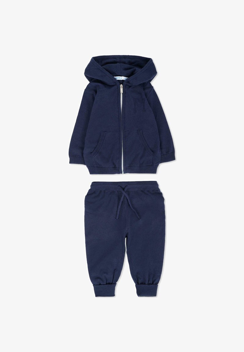 Granatowa kurtka z kapturem na zamek błyskawiczny z przednimi kieszeniami oraz dopasowane spodnie dresowe z elastycznym paskiem w talii i mankietami przy nogawkach. Miękka tekstura materiału.