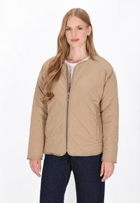 Beige gesteppte Jacke mit einem Reißverschluss vorne, Rundhalsausschnitt und langen Ärmeln. Texturiertes Material und subtile Nähedetails sind sichtbar.