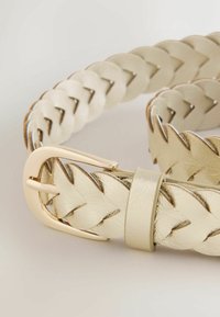 Punutud nahkrihm metallkuldses toonis, läikiva hõbedase pandlaga. Omab sujuvat tekstuuri ja reguleerimisõltsi.