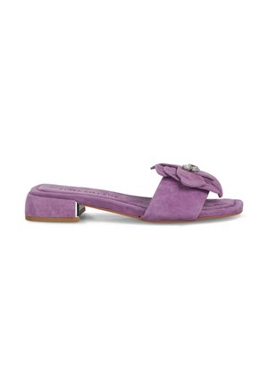 Sandal de ante morado con un bajo tacón cuadrado y un gran adorno de flor de tela decorado con un strass. Suela plana, diseño de punta abierta.