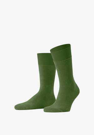 Grüne Baumwollsocken mit einem gerippten Bund und einer glatten Textur. Sie haben eine standardisierte Form mit verstärkten Zehen- und Fersenbereichen.