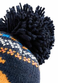 Bonnet tricoté de couleur marine avec des motifs multicolores, surmonté d'un grand pompon texturé en grosse laine.