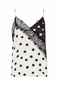 Camisola a pois bianca e nera con bordino in pizzo. Presenta un design incrociato e sottili spalline regolabili. Texture del tessuto morbida.