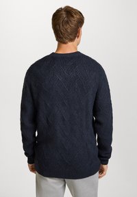 Navyblauwe trui met een textuur in een chevronpatroon, lange mouwen en een ronde halslijn. Gemaakt van een dikke, comfortabele stof.