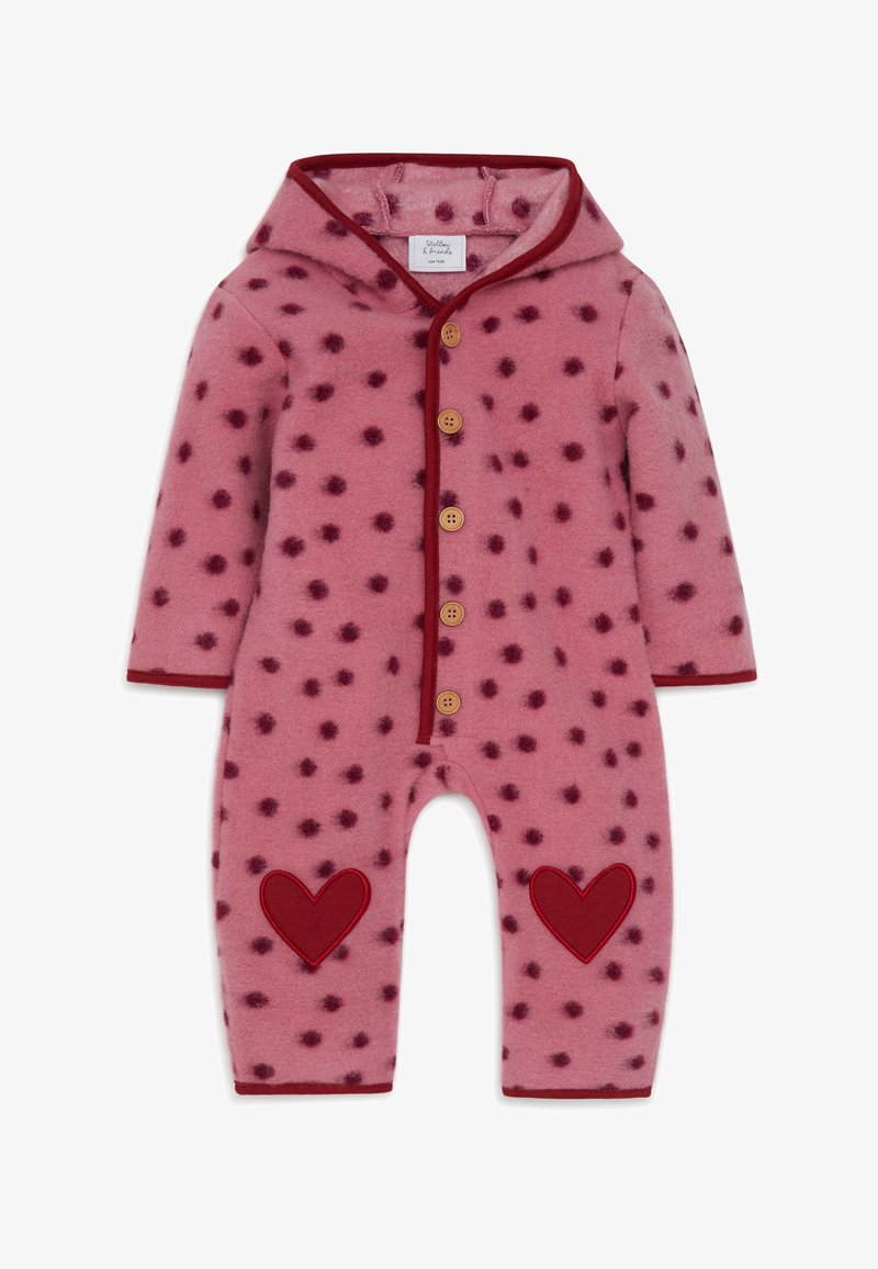 Roze fleece jumpsuit met donkerroze stippen, een capuchon, rode afwerking, houten knopen en rode hartapplicaties op de benen.