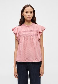 Ružičasta pamučna bluzica s teksturiranim cvjetnim uzorkom, volanima na rukavima i naboranim detaljima na prsima. Okrugli izrez, širok kroj.