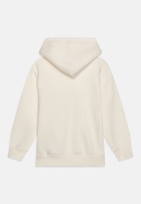 Felpa color crema con tasca a marsupio, cappuccio con lacci, polsini e orlo a coste, realizzata in tessuto morbido e leggero.