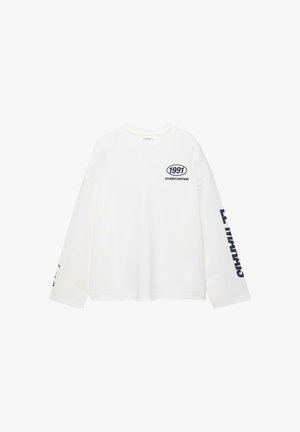 Biała koszulka z długim rękawem wykonana z bawełny, z okrągłym dekoltem, nadrukiem logo na przodzie oraz granatowym napisem na lewym rękawie.