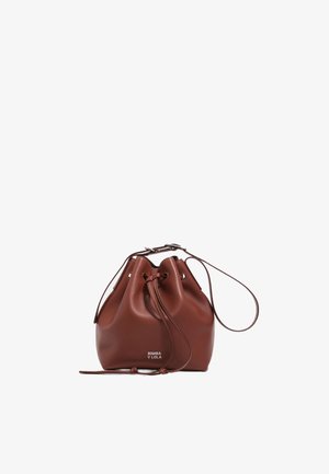 Sac seau en cuir marron avec bandoulière réglable et fermeture à cordon, avec le logo "Bimba y Lola" sur le devant.