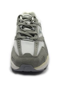 Zapatilla de running gris con parte superior de malla, acentos de ante, cordones redondos y una suela acolchada con patrones de banda de rodadura multidireccionales.