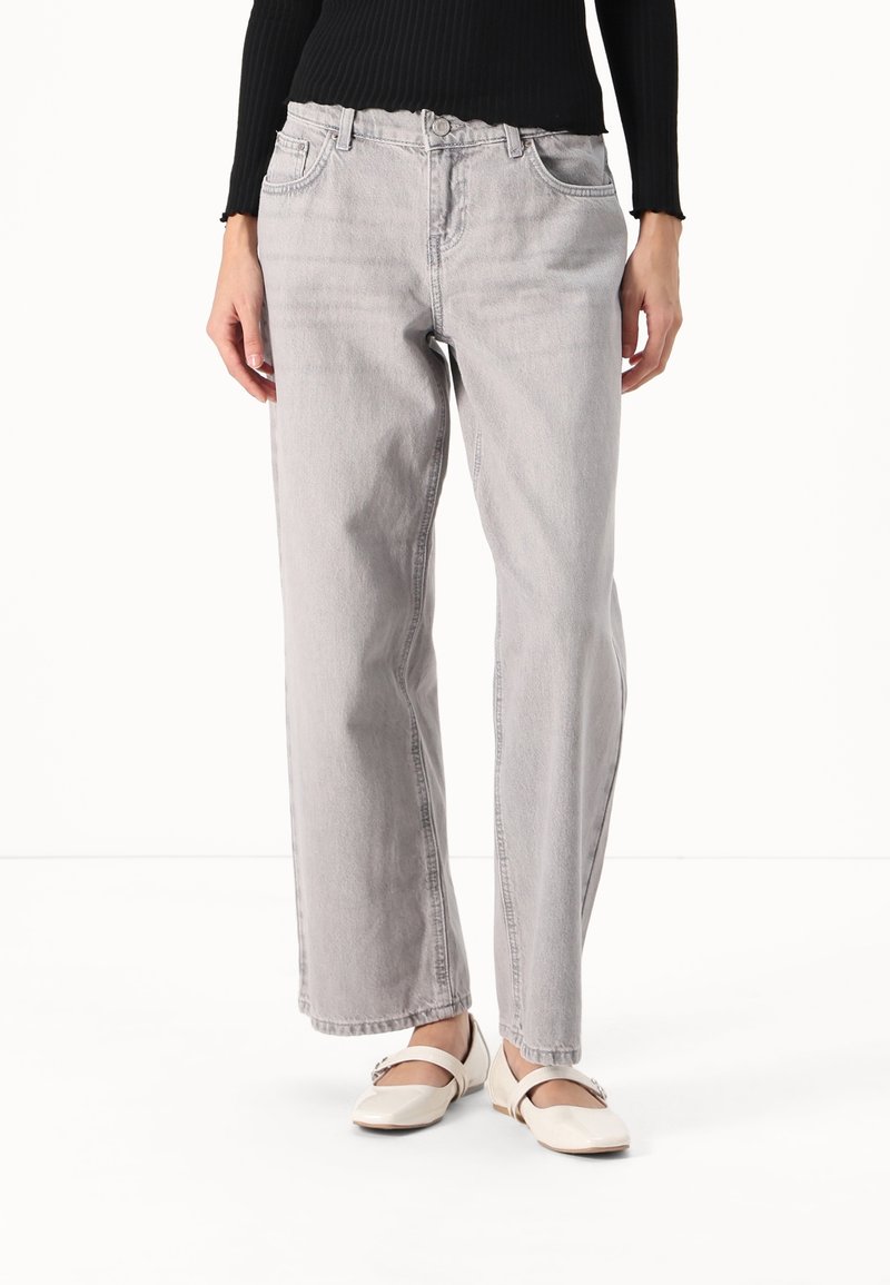 Ljust grå högmidjade jeans med avslappnad passform, subtil blekning och en mjuk denimtextur. Har en traditionell knapp- och dragkedjefly.