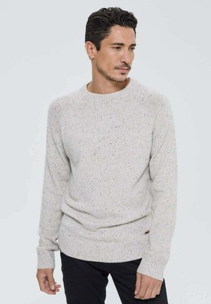 Pull gris clair en tricot texturé, col rond et poignets côtelés. Des éclats multicolores subtils ajoutent du détail au tissu.