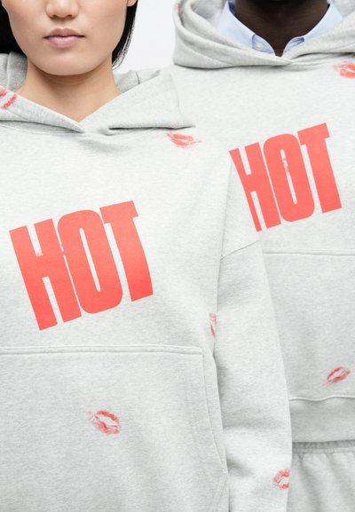Γκρι φούτερ με κουκούλα, με μεγάλα κόκκινα γράμματα "HOT" και τυπώματα φιλημάτων. Κατασκευασμένο από απαλό ύφασμα, με μπροστινές τσέπες και κουκούλα �με κορδόνι.