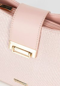Borsa a tracolla rosa con texture e design intrecciato, flap in pelle liscia e hardware tono oro. Dotata di chiusura con zip e etichetta metallica con marchio.