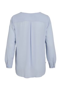 Blouse bleu clair en tissu lisse, avec manches longues, encolure arrondie et un pli au dos.