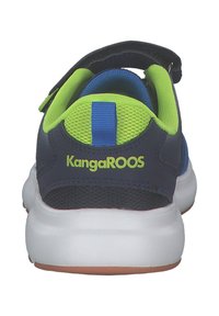 KangaROOS-kengät sinisen ja vihreän sävyissä, joissa on teksturoitu yläosa, tarranauha ja valkoinen pohja. Varustettu takana olevalla nostonauhalla ja logotiedoilla.